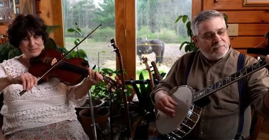 A picture of a woman playing a fiddle and a man playing a banjo singing